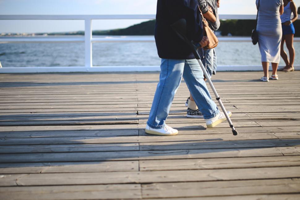 Free Image of Old Walking crutch hardworking injury jeans pier walk woman person man male people cleaner adult happy smile business 