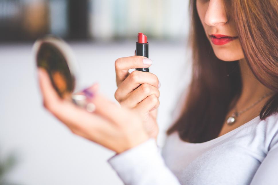 Free Image of Woman Examining Lipstick in Mirror 