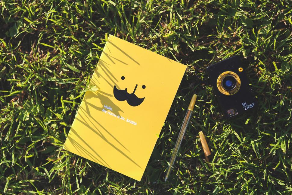 Free Image of Yellow Notebook With Mustache and Camera 