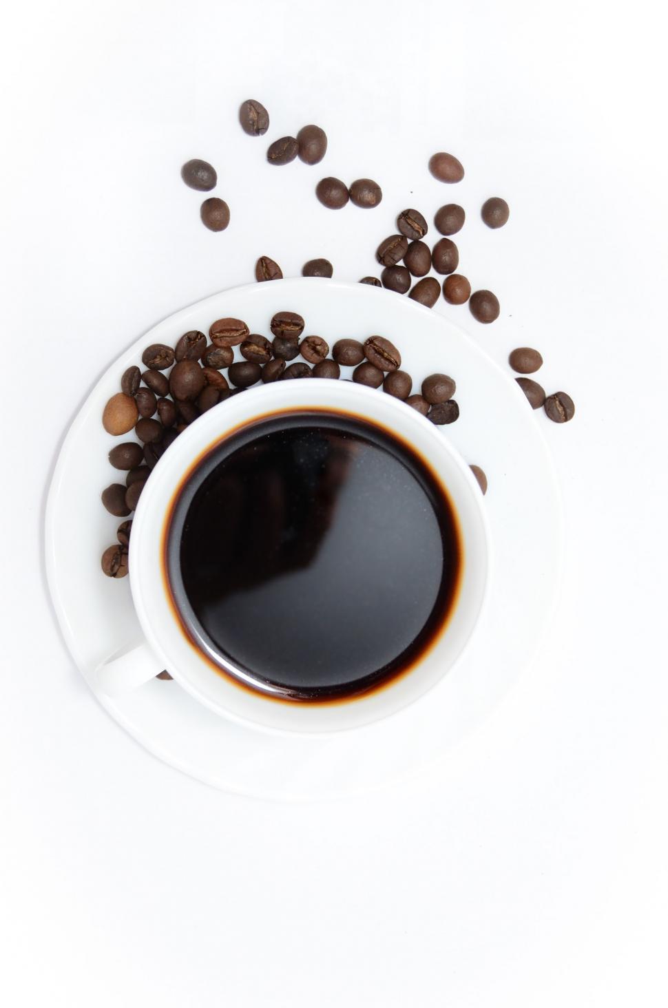 Free Image of A Cup of Coffee Surrounded by Coffee Beans 