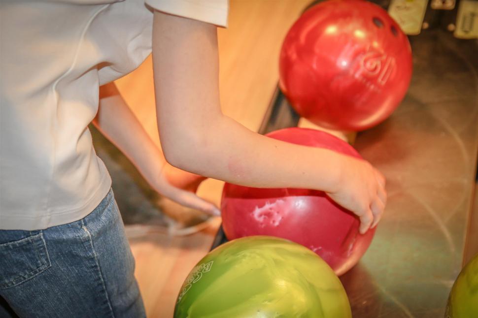 Free Image of Young Girl Standing Next to Pile of Balls 