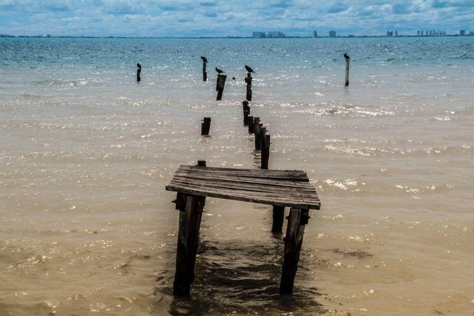 Free Image of Wooden Bench in the Middle of a Body of Water 