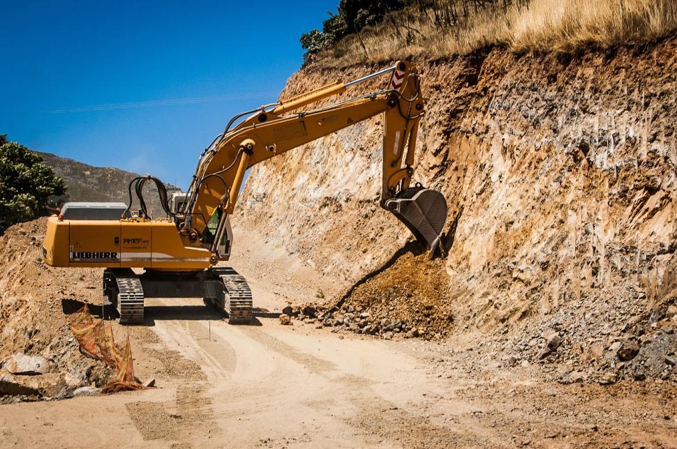 Free Image of Construction Vehicle Driving Down a Dirt Road 