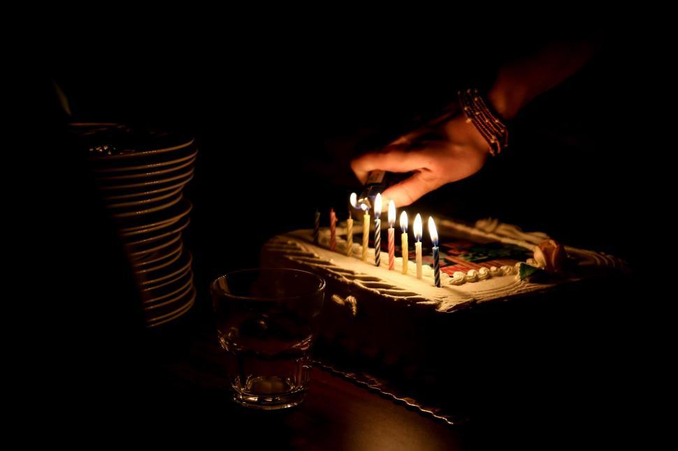 Free Image of Person Lighting Candles on Cake in the Dark 