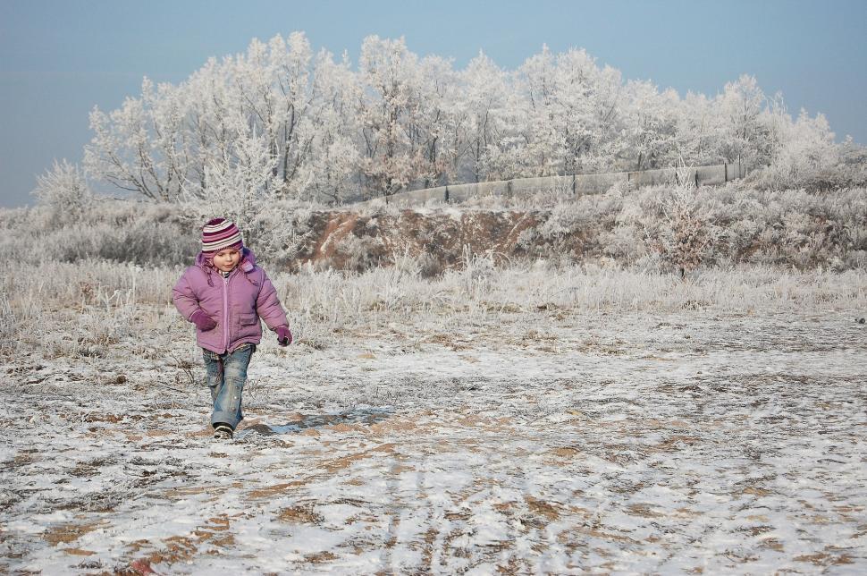 Free Image of Little Girl in Pink Jacket and Hat Walking in the Snow 