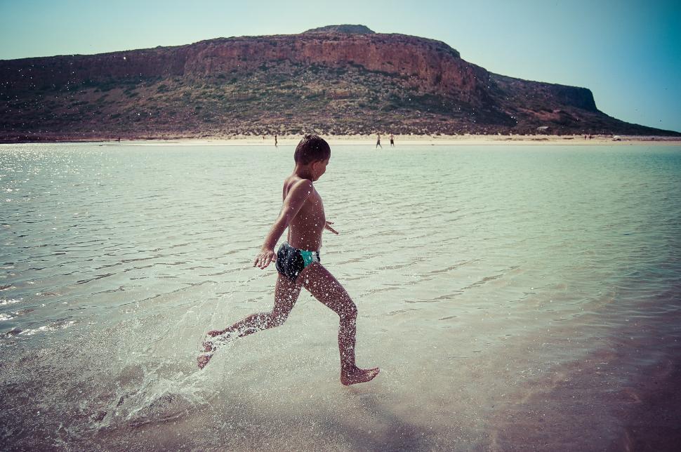 Free Image of Young Boy Running in Water 