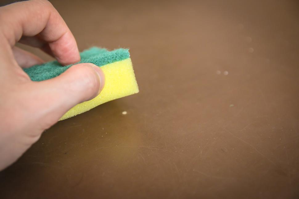 Free Image of Person Cleaning a Table With a Sponge 