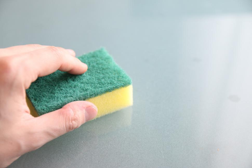 Free Image of Person Cleaning Table With Sponge 