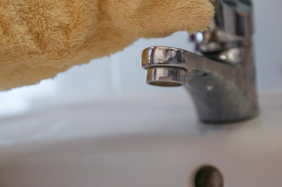 Free Image of Close Up of Persons Hand Holding Towel Over Sink 