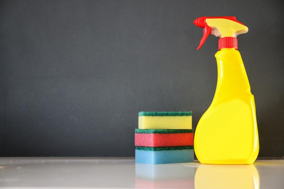 Free Image of Yellow Cleaner Bottle Next to Stack of Sponges 