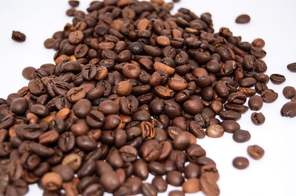 Free Image of A Pile of Coffee Beans on a White Surface 