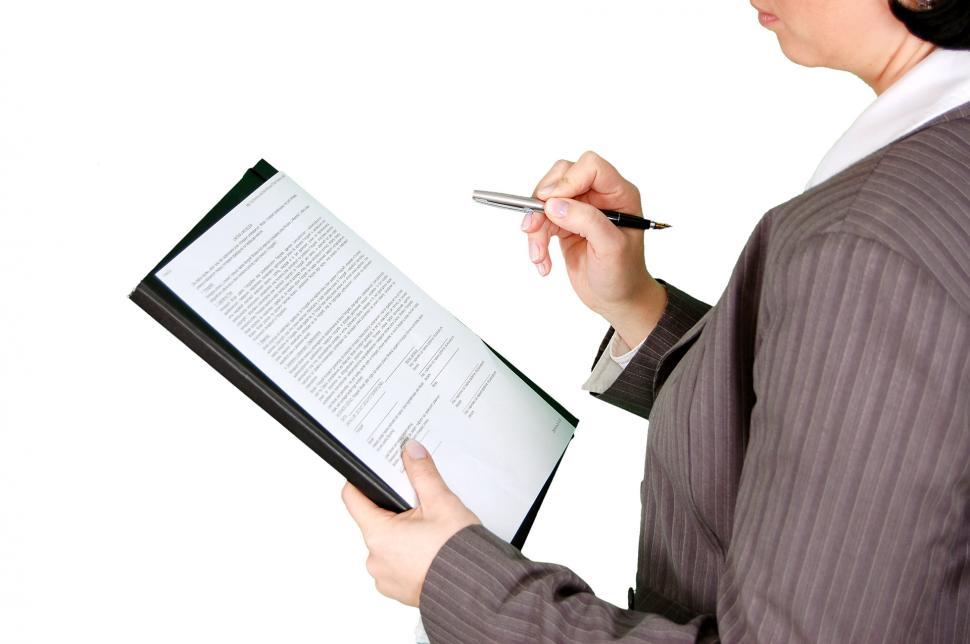 Free Image of Woman in Suit Writing on Clipboard 