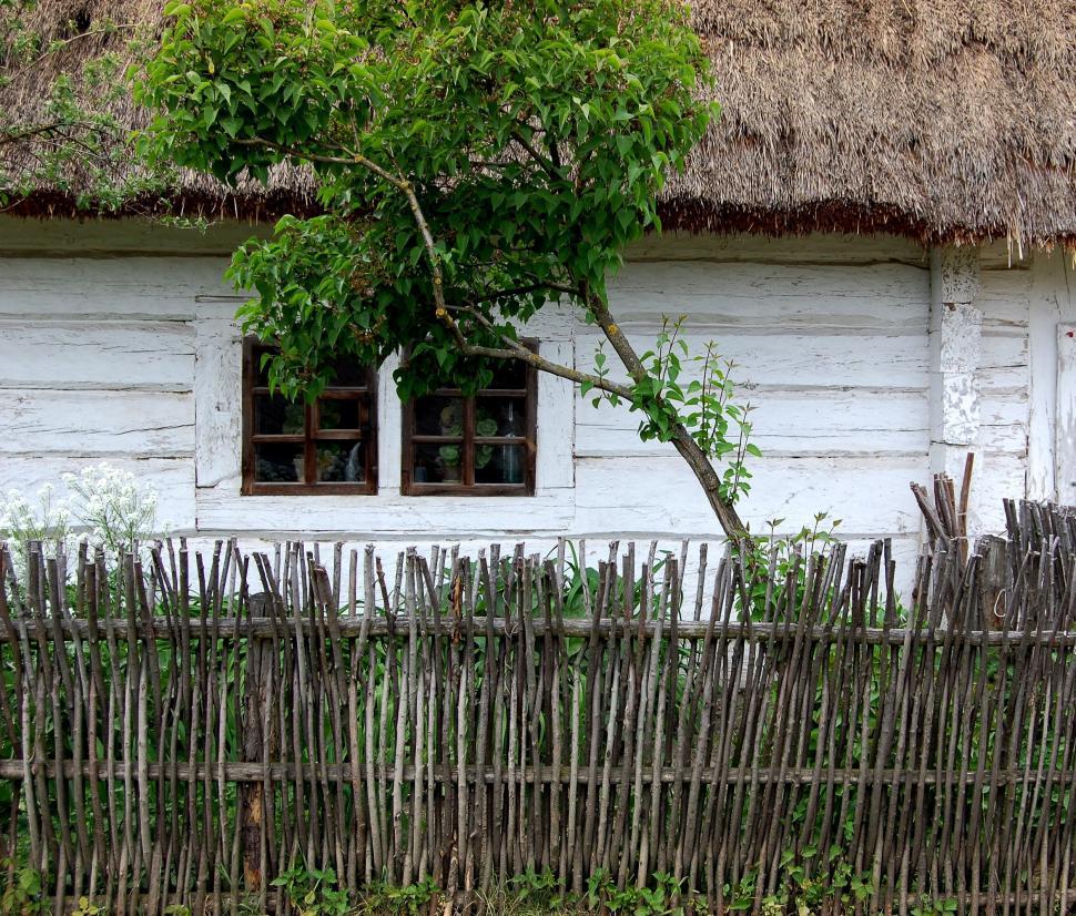 Free Image of White House With Thatched Roof and Wooden Fence 