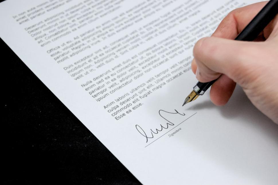 Free Image of Person Holding Pen and Writing on Paper 