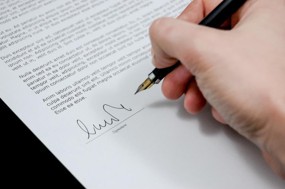 Free Image of Person Holding Pen and Writing on Paper 