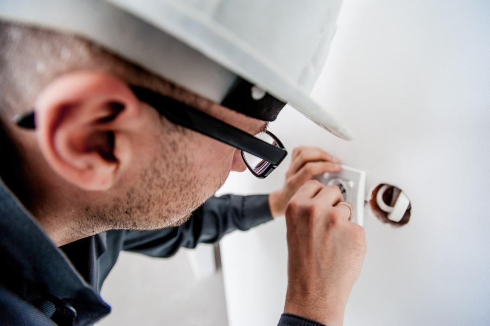 Free Image of Man in Hard Hat Fixing Light Switch 