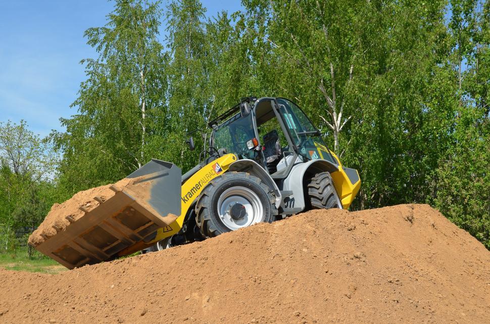 Free Image of Yellow and Black Bulldozer Digging Dirt in a Field 