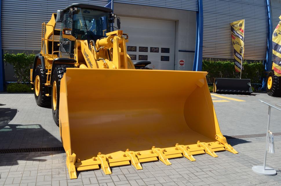 Free Image of Large Yellow Bulldozer Parked in Front of Building 