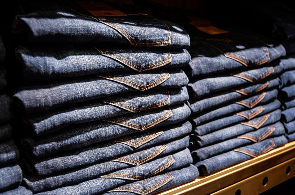 Free Image of Stack of Blue Jeans on Wooden Shelf 