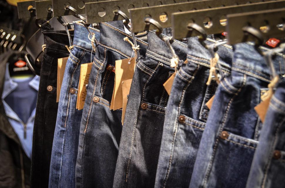 Free Image of Row of Jeans Hanging on a Rack in a Store 