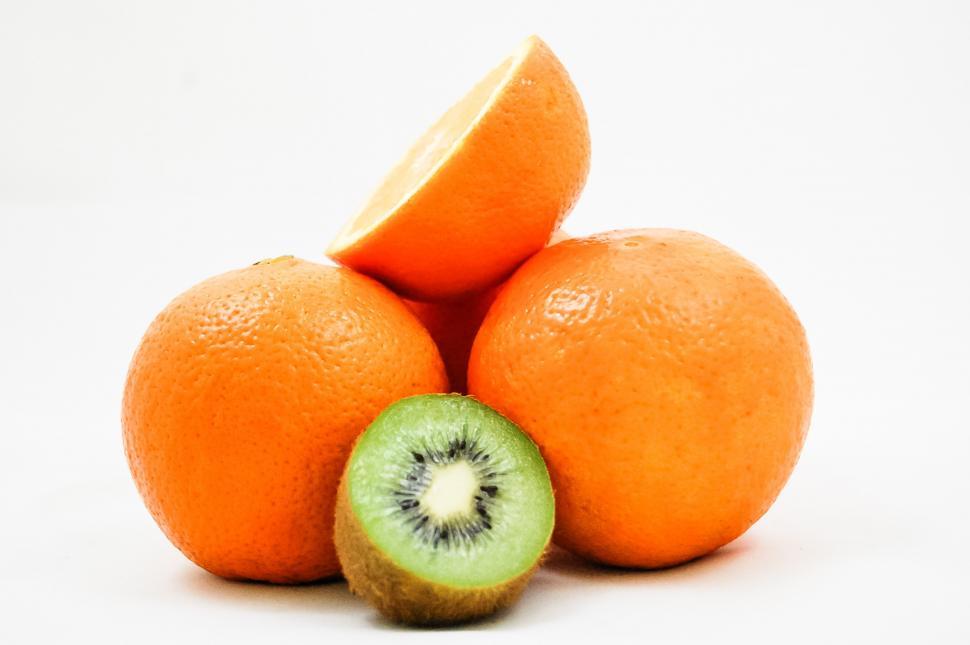 Free Image of Three Oranges With a Kiwi Cut in Half 