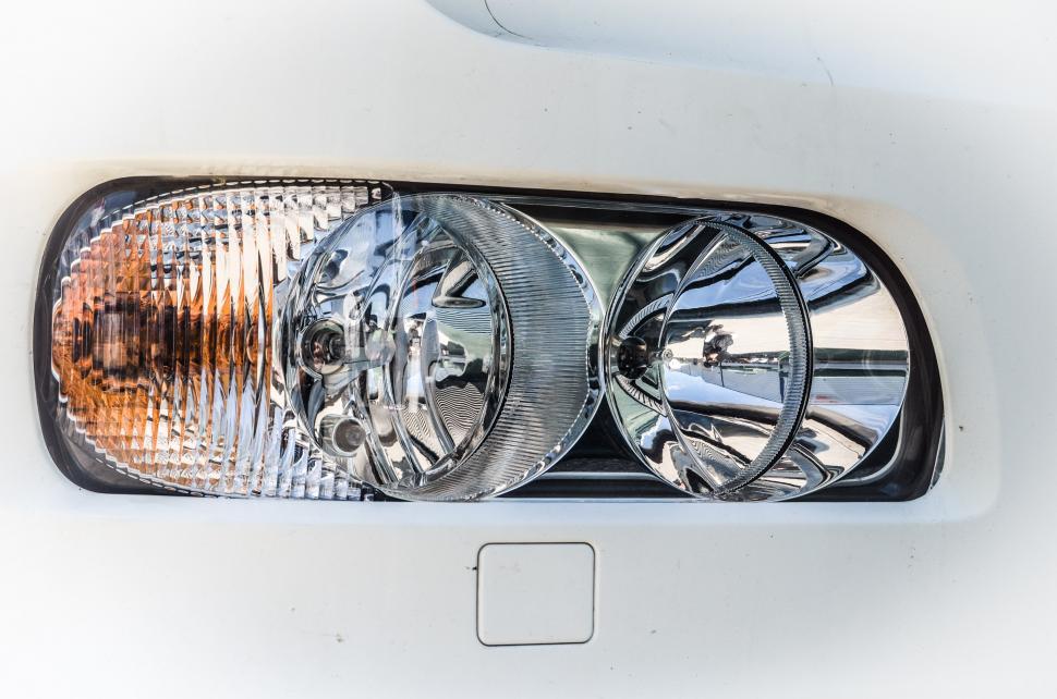 Free Image of Close Up of a Headlight on a White Car 