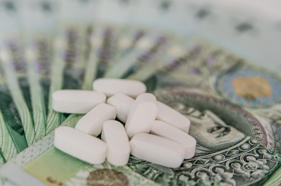 Free Image of Stack of Pills on Top of a Hundred Dollar Bill 