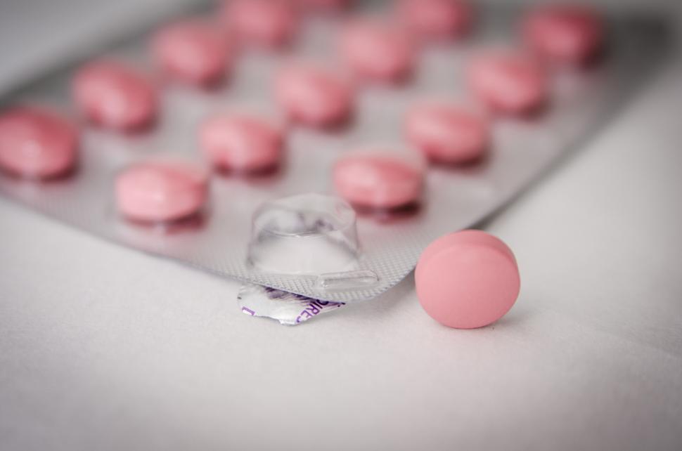 Free Image of Close Up of Pink Pills on White Surface 