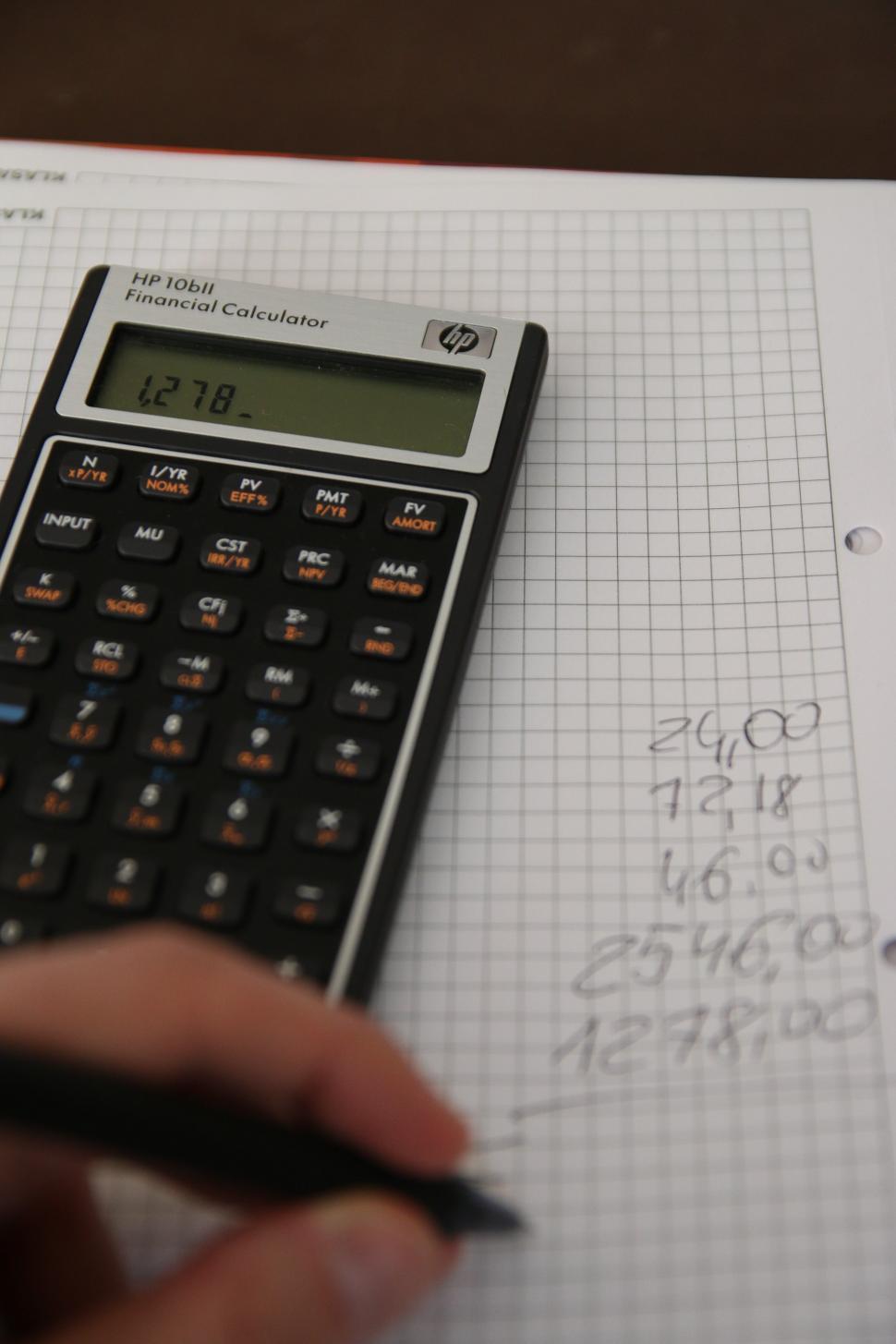 Free Image of Person Using Calculator on Sheet of Paper 