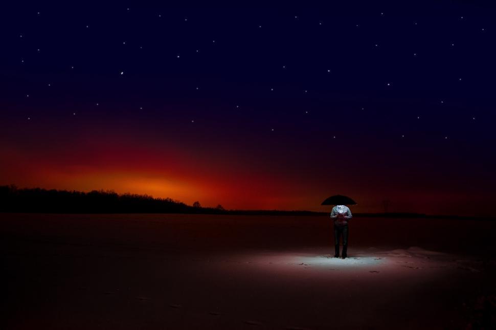 Free Image of Person Holding Umbrella Standing in Field at Night 
