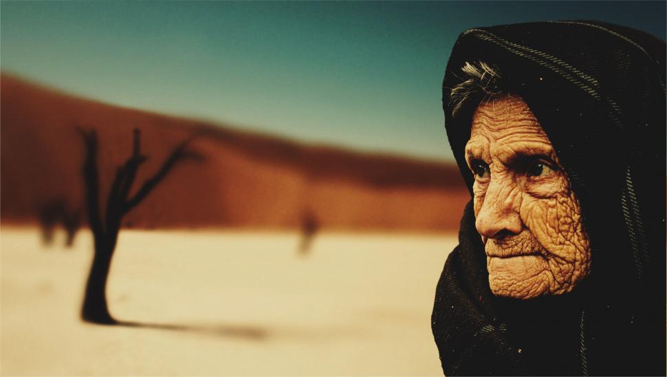 Free Image of Old Woman in Black Hood With Tree in Background 