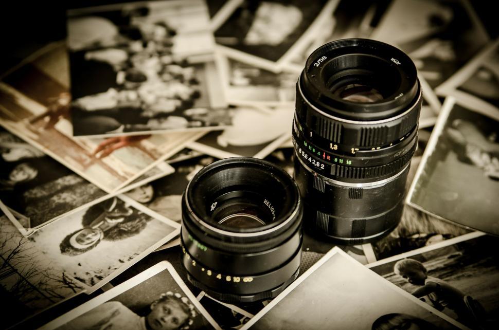 Free Image of Camera Lens on Top of Pile of Pictures 