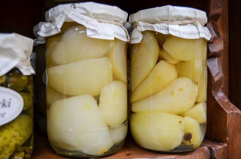 Free Image of Two Jars Filled With Pickles on a Shelf 
