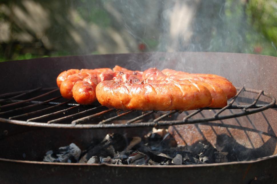 Free Image of Two Hot Dogs Cooking on a Grill 