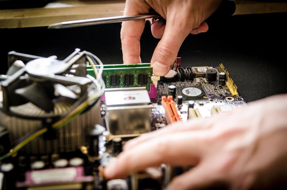 Free Image of Person Working on a Computer Motherboard 