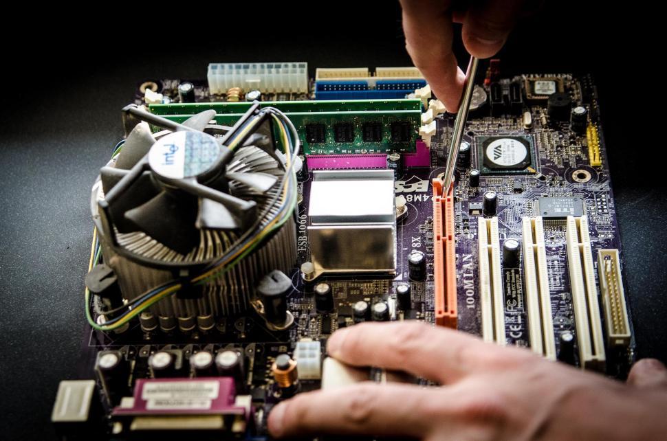 Free Image of Person Working on a Computer Motherboard 