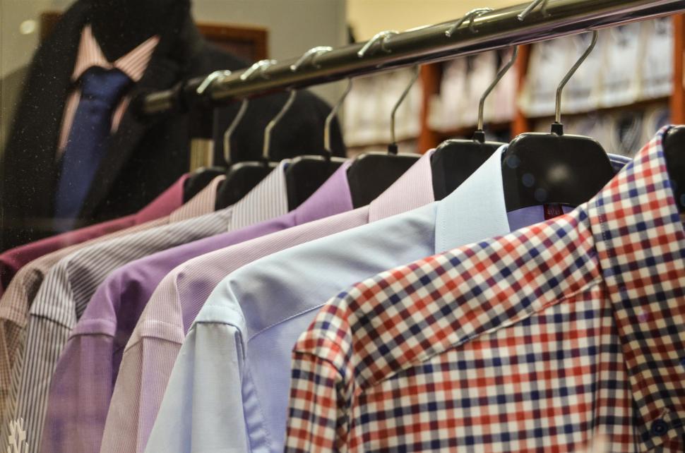 Free Image of Woman Browsing Rack of Shirts in Store 