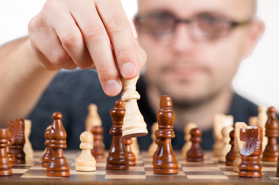 Free Image of Man Playing Chess on a Chess Board 