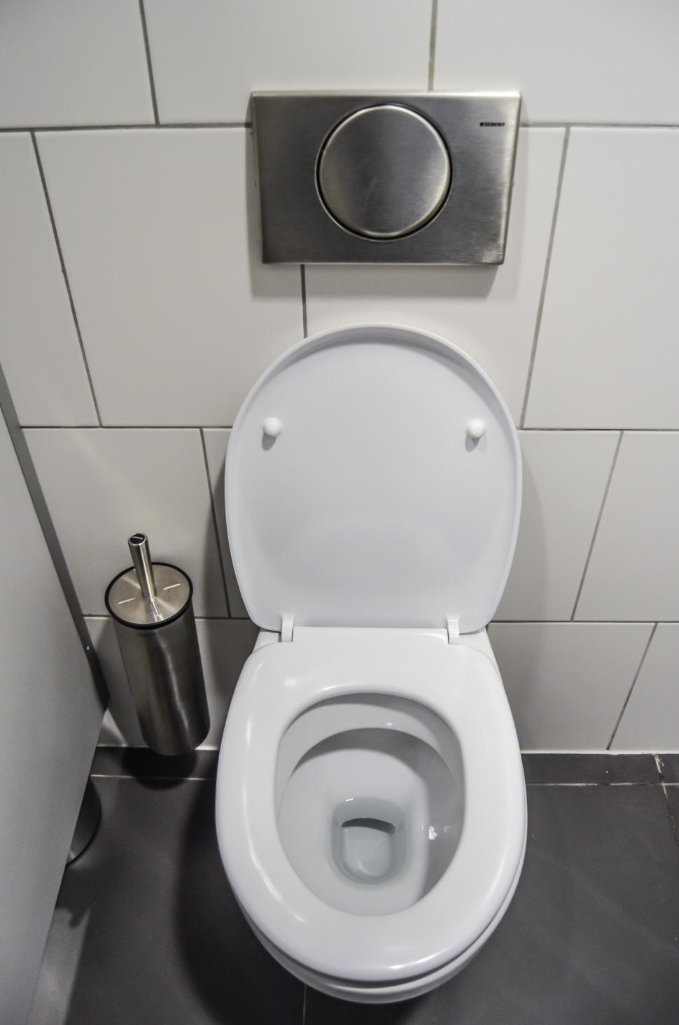 Free Image of White Toilet Next to Trash Can in Bathroom 