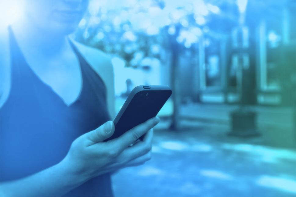 Free Image of Woman Holding Smartphone - Colorized Hazy Looks 