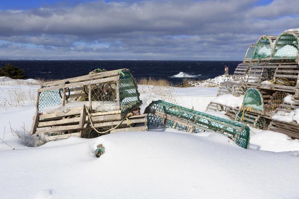 Free Image of Snow covered lobster traps near ocean 