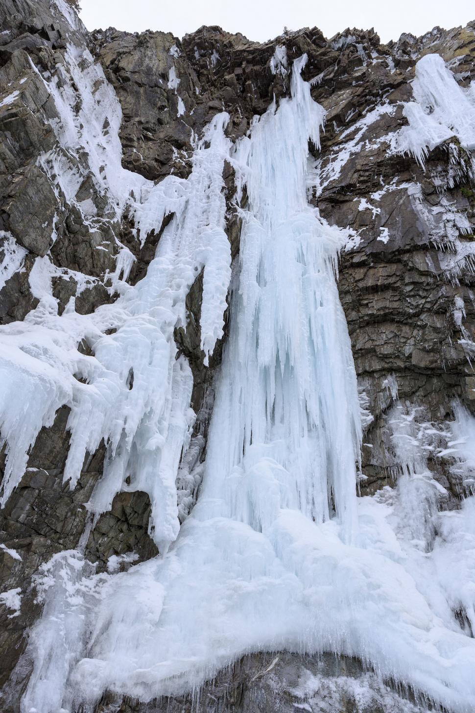 Free Image of Icicles on a wall of rock  