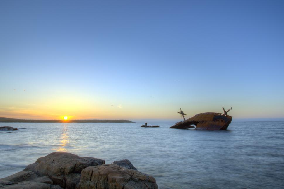 Free Image of Shipwreck with rocks and sunset 