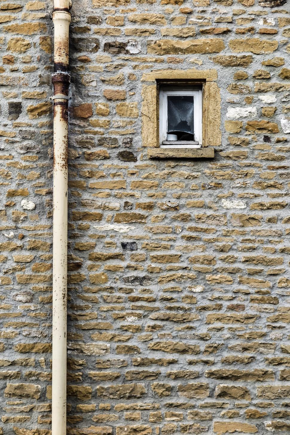Free Image of Pipe along a masonry wall 
