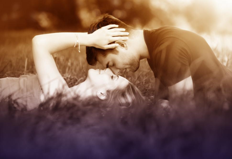 Free Image of Couple Kissing Laying on the Grass 