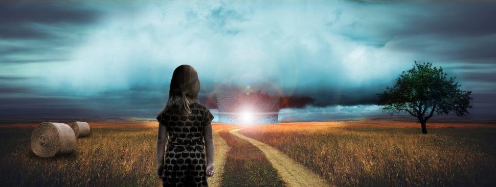 Free Image of Woman Standing in Field With Storm in Background 