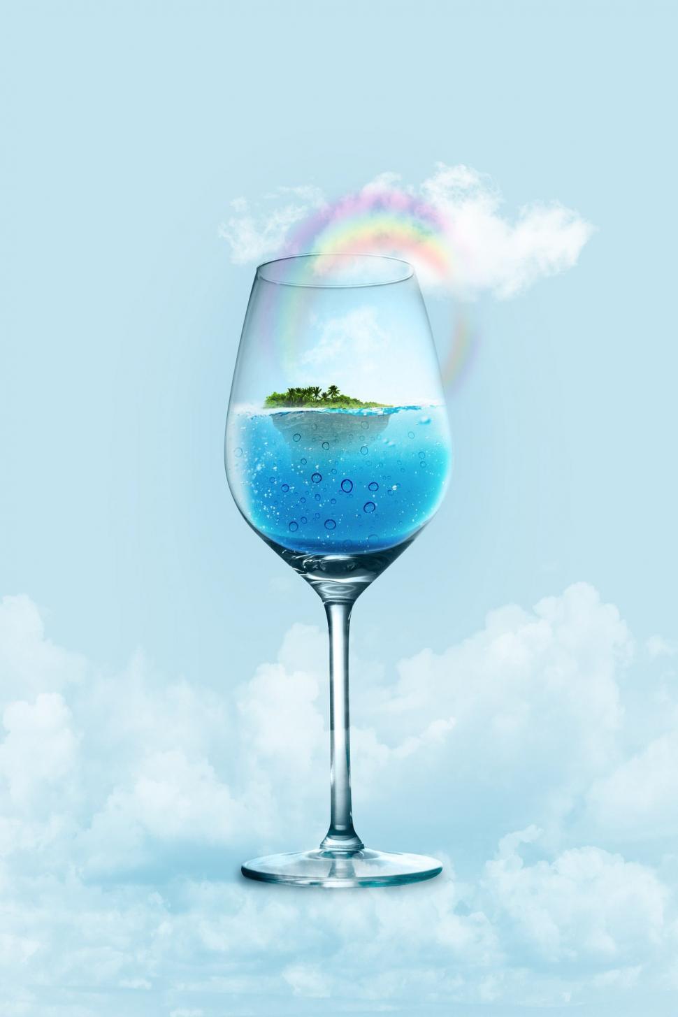 Free Image of Glass Filled With Blue Liquid Showing Small Island 
