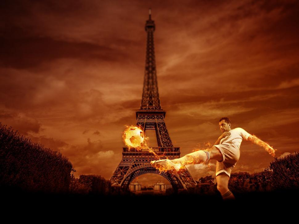 Free Image of Man Kicking Soccer Ball in Front of Eiffel Tower 