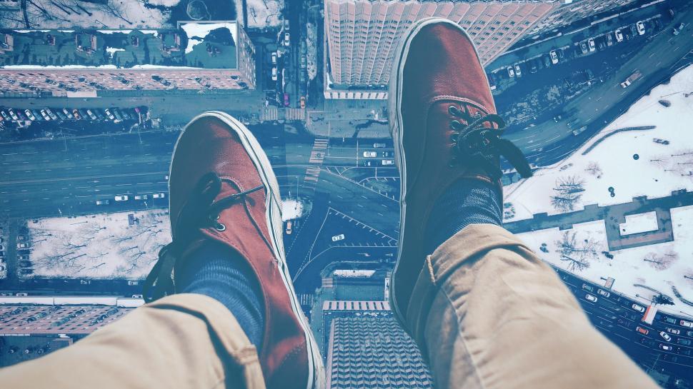 Free Image of Feet Standing on Top of Building 