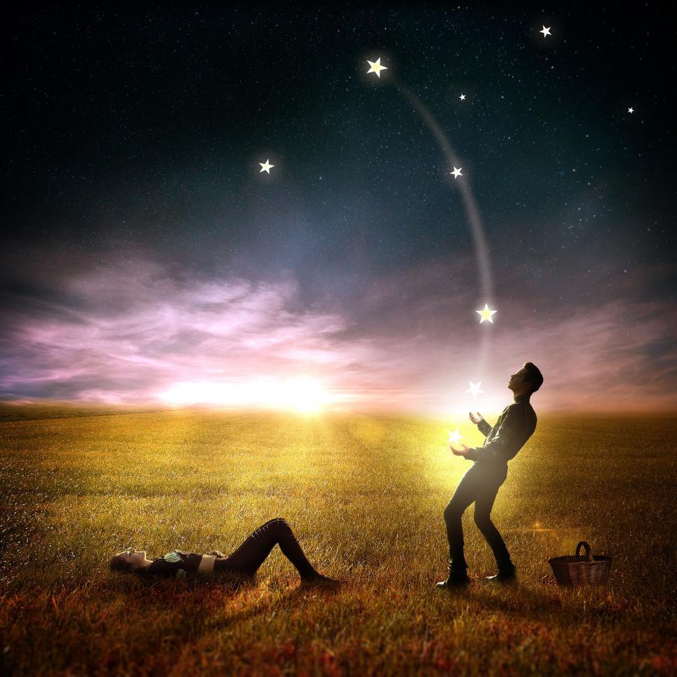 Free Image of Couple Standing in Field Under Star Filled Sky 